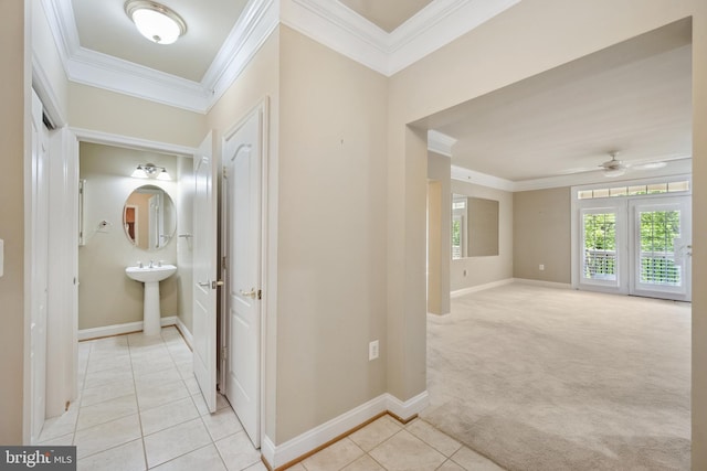 hallway with baseboards, ornamental molding, and light tile patterned floors