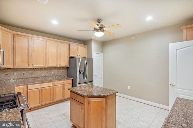 kitchen featuring a kitchen island, a ceiling fan, light brown cabinetry, light tile patterned floors, and stainless steel appliances