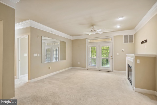 unfurnished living room with a ceiling fan, light colored carpet, ornamental molding, and visible vents