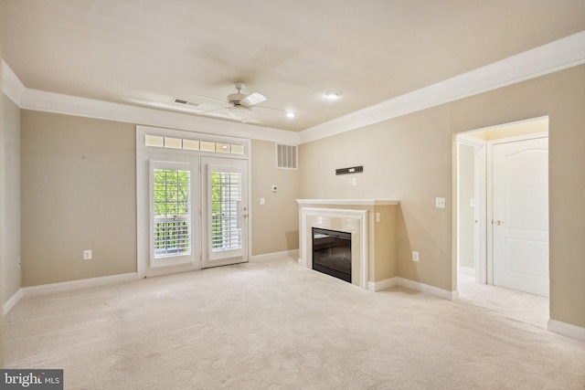 unfurnished living room featuring visible vents, crown molding, ceiling fan, carpet flooring, and a premium fireplace