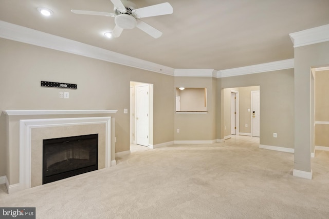 unfurnished living room featuring crown molding, carpet floors, baseboards, ceiling fan, and a premium fireplace