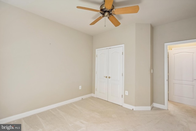 unfurnished bedroom with a ceiling fan, baseboards, light colored carpet, and a closet