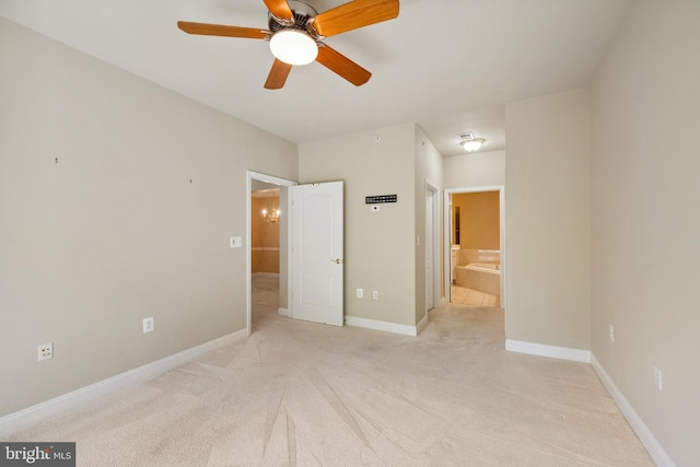 unfurnished bedroom with baseboards, light carpet, and connected bathroom