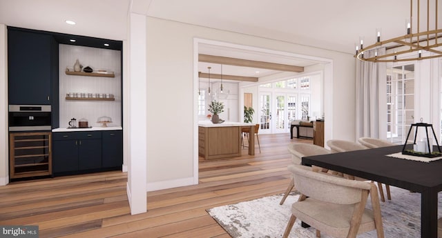 dining space featuring bar, beverage cooler, french doors, recessed lighting, and light wood-type flooring