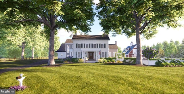 view of front facade with fence, a chimney, and a front lawn
