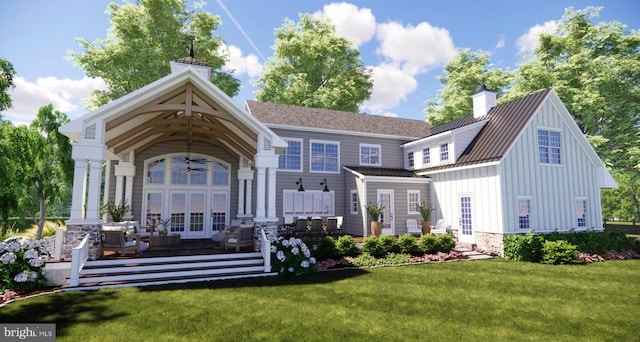 rear view of house with board and batten siding, a chimney, french doors, a yard, and metal roof