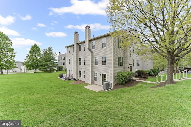493 Stoneglen St, Collegeville, PA 19426 - rear view of property with a lawn, a chimney, and central AC unit