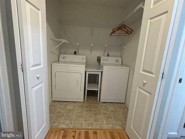clothes washing area featuring laundry area, washing machine and dryer, and light tile patterned floors