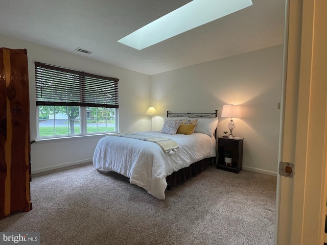 carpeted bedroom featuring a skylight, baseboards, and visible vents