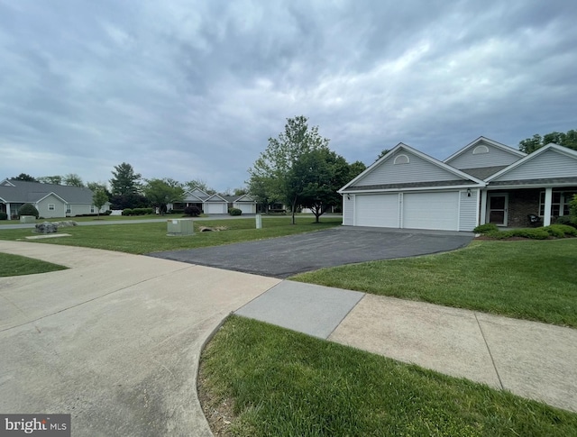 view of front facade featuring an attached garage, driveway, and a front lawn
