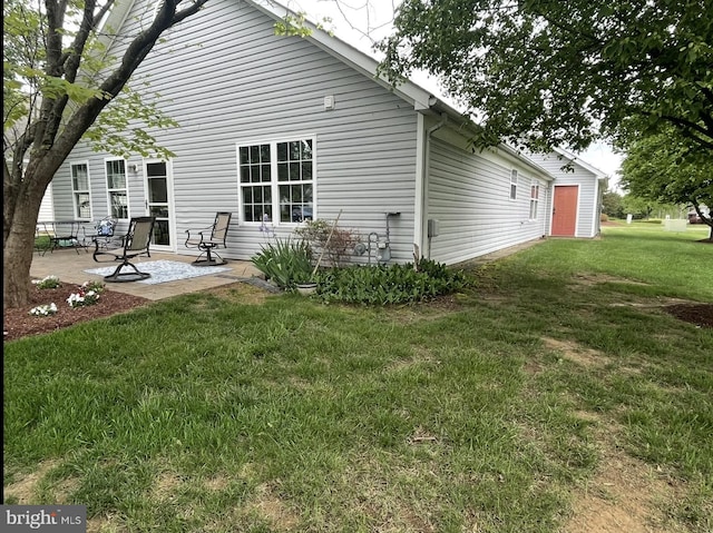 rear view of property featuring a patio and a lawn
