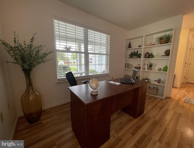 office area with baseboards and light wood-style flooring