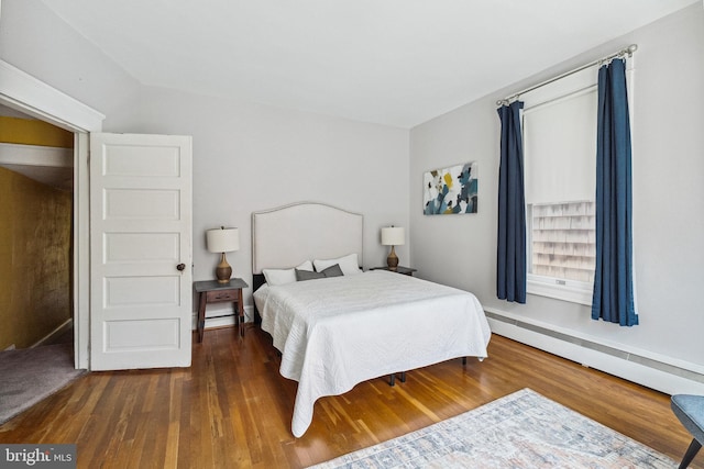 bedroom featuring wood finished floors and baseboard heating