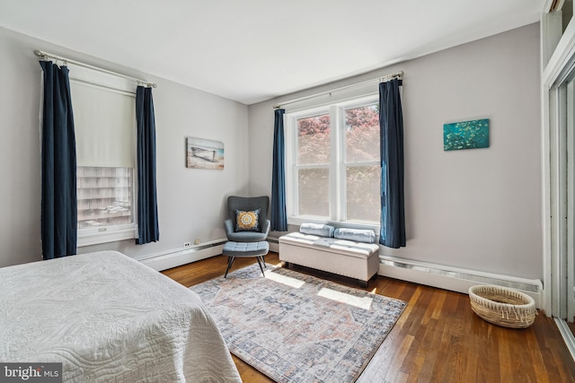 bedroom featuring a baseboard heating unit and wood finished floors