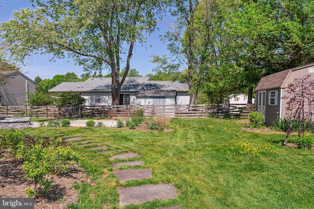 view of yard with an outdoor structure, a fenced backyard, and a storage shed