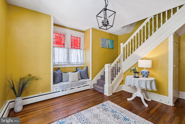 stairway with baseboards, an inviting chandelier, wood finished floors, and a baseboard radiator