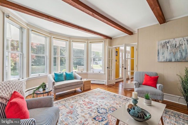 living area featuring wood finished floors, beam ceiling, baseboards, wooden walls, and a baseboard heating unit