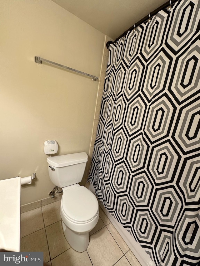 full bathroom featuring tile patterned flooring, a shower with shower curtain, and toilet