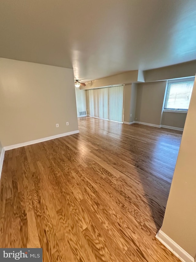 spare room with baseboards, a ceiling fan, and wood finished floors