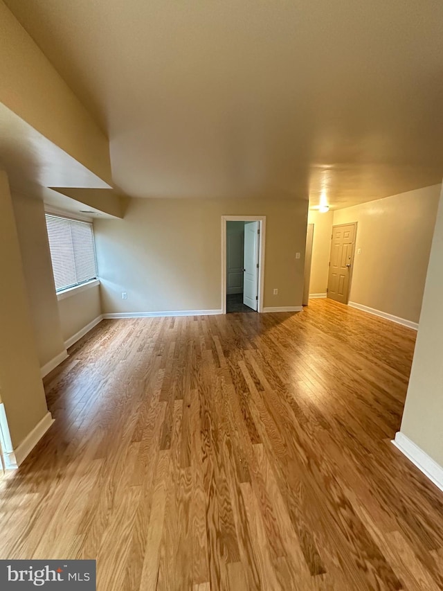 unfurnished living room with baseboards and wood finished floors