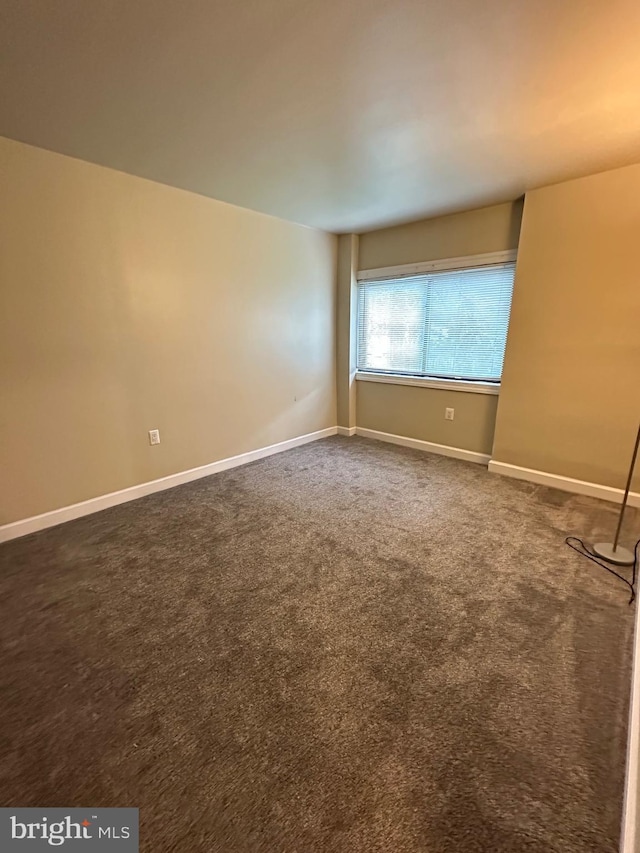carpeted spare room with baseboards