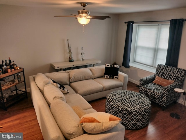 living area with baseboards, ceiling fan, and wood finished floors