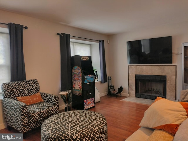 living room with baseboards, wood finished floors, and a fireplace