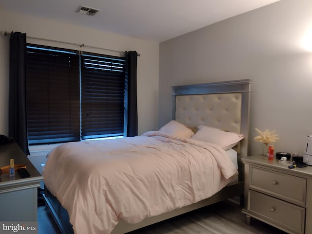 bedroom with visible vents and wood finished floors