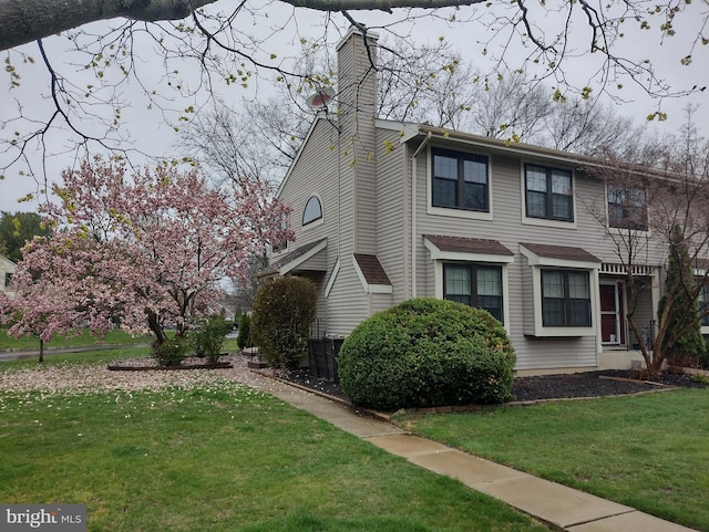 view of side of home featuring a lawn and a chimney