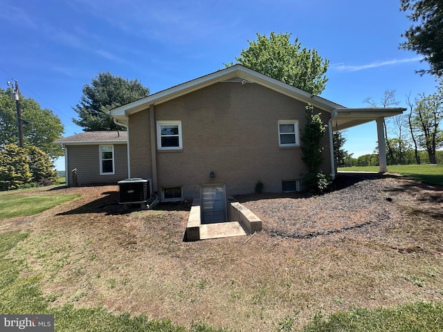 111 Heron Ln, Augusta, WV 26704 - rear view of house with central AC, brick siding, and a lawn