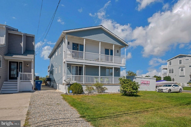 view of front facade with a balcony, covered porch, and a front yard