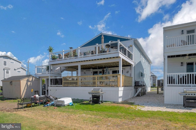 back of house featuring a lawn, an outdoor structure, and a shed