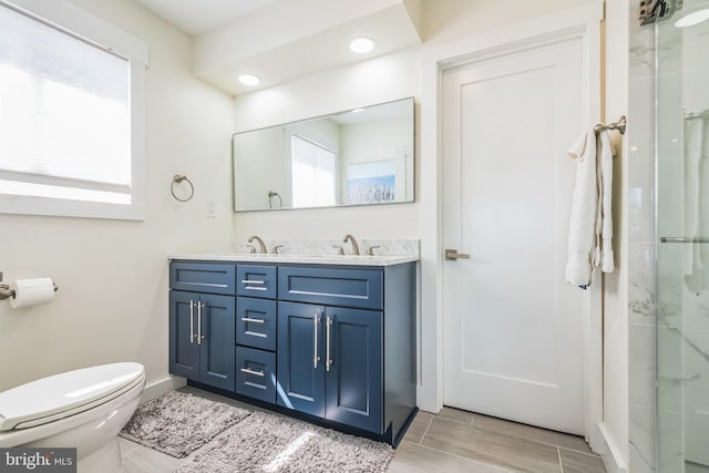 full bath featuring toilet, a sink, and a healthy amount of sunlight