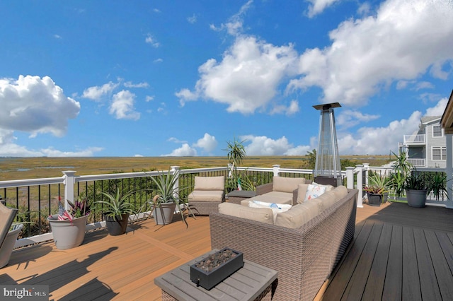 wooden deck featuring an outdoor living space with a fire pit