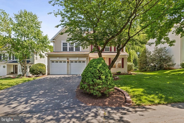 view of front facade featuring asphalt driveway, a garage, and a front yard