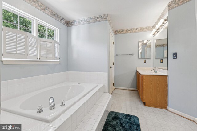full bath with baseboards, vanity, a garden tub, and tile patterned floors