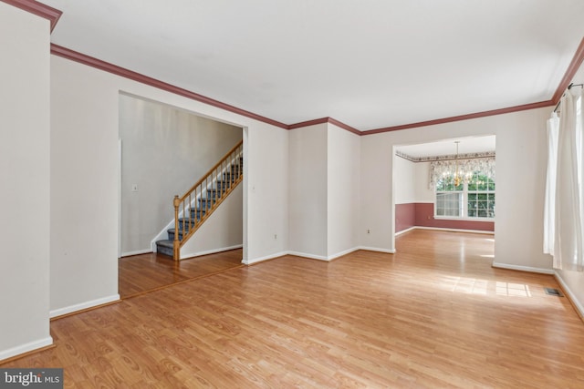 unfurnished living room featuring a chandelier, light wood-type flooring, baseboards, stairs, and ornamental molding