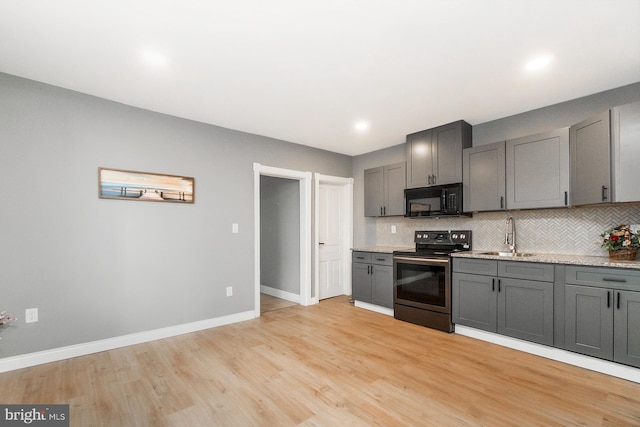 kitchen with black microwave, a sink, electric stove, tasteful backsplash, and gray cabinetry
