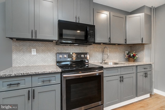 kitchen with black microwave, gray cabinets, a sink, and stainless steel range with electric stovetop