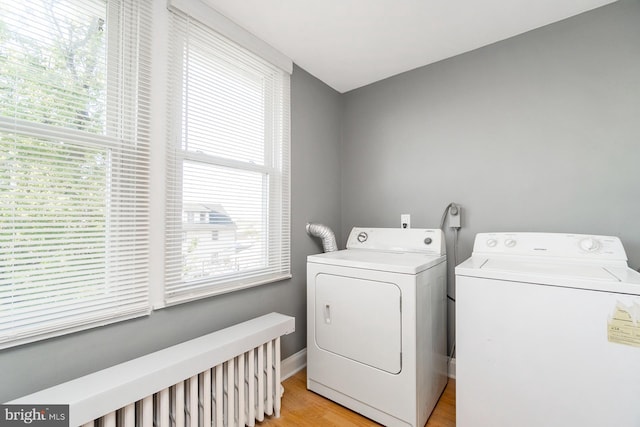 laundry room with plenty of natural light, laundry area, light wood-type flooring, and washing machine and clothes dryer