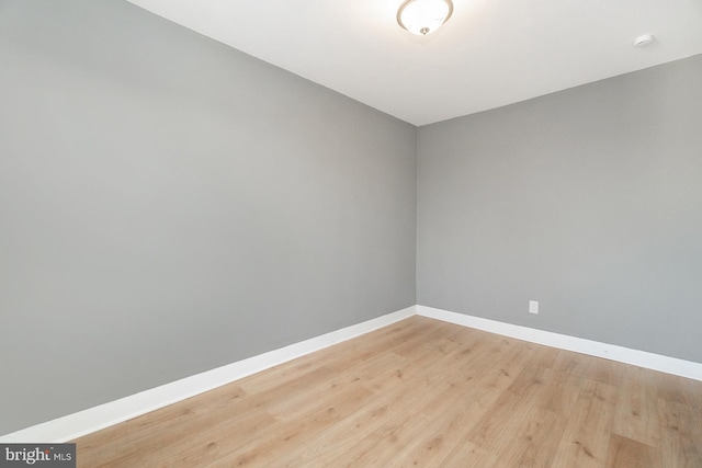empty room with baseboards and light wood-style flooring