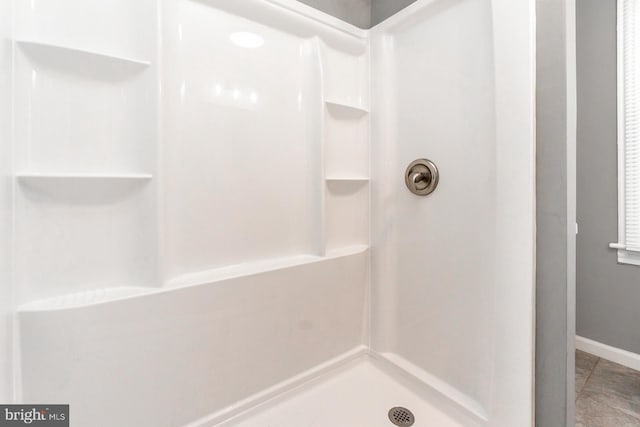 full bathroom featuring baseboards and walk in shower