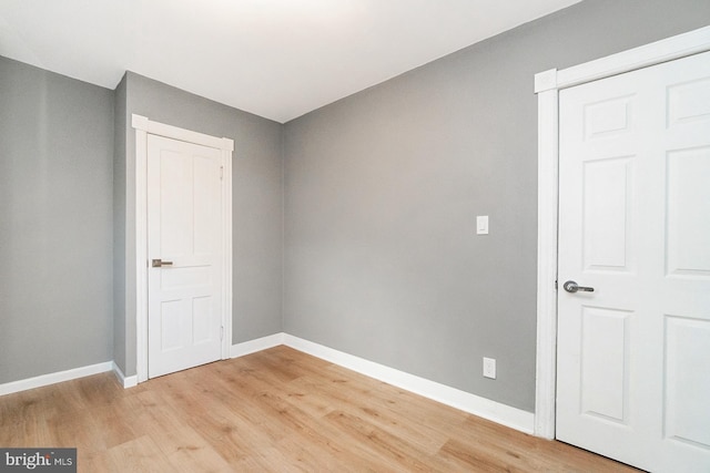 unfurnished room featuring baseboards and light wood-style flooring