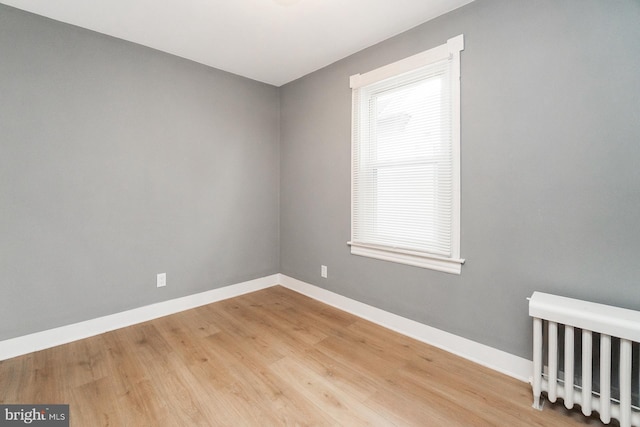 unfurnished room with baseboards and wood finished floors