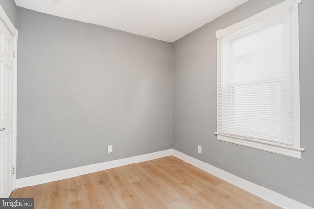 unfurnished room featuring baseboards and light wood-style flooring