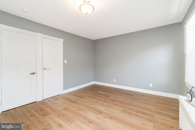 unfurnished bedroom with light wood-type flooring and baseboards