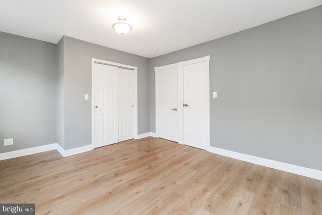 unfurnished bedroom with baseboards, a closet, and light wood finished floors