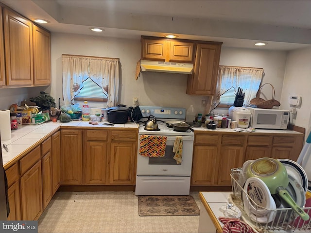 1646 W Norwegian St, Pottsville, PA 17901 - kitchen with white appliances, tile counters, under cabinet range hood, and recessed lighting