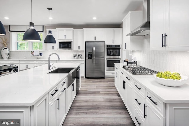 2682 Broadhorn Dr, Odenton, MD 21113 - kitchen featuring wall chimney range hood, a spacious island, light countertops, a sink, and stainless steel appliances