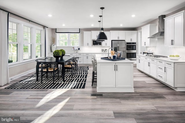 2682 Broadhorn Dr, Odenton, MD 21113 - kitchen featuring light wood-style floors, appliances with stainless steel finishes, white cabinets, and wall chimney range hood